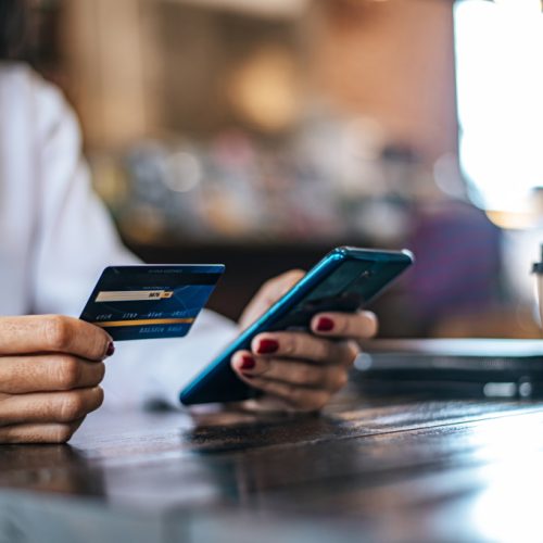 Pay for goods by credit card through a smartphone in a coffee shop. Pay for goods by credit card through a smartphone in a coffee shop.