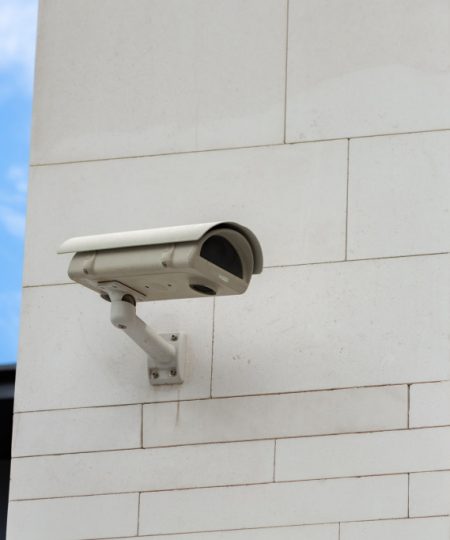 Surveillance camera built into the stone wall of the building, close up