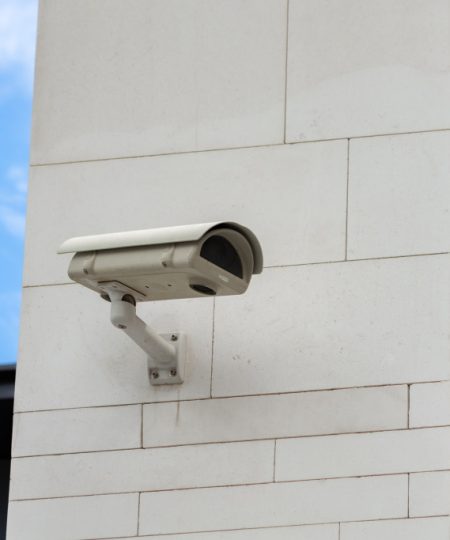 Surveillance camera built into the stone wall of the building, close up Surveillance camera built into the stone wall of the building, close up